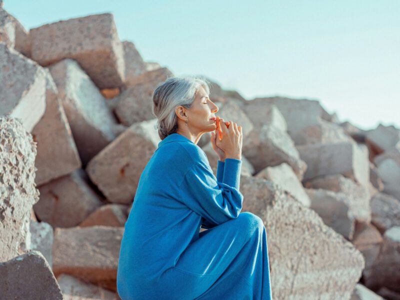 Calm woman sitting on the rocks